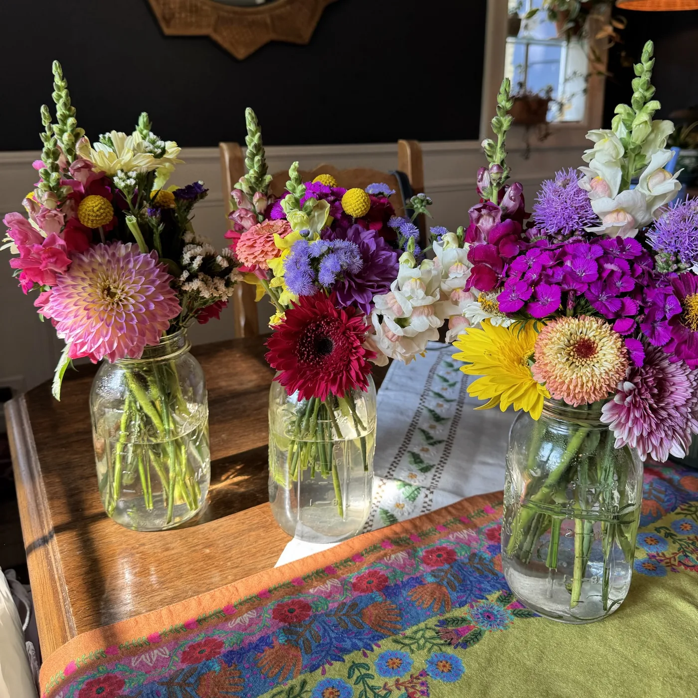 Three fresh mixed bouquets in mason jars