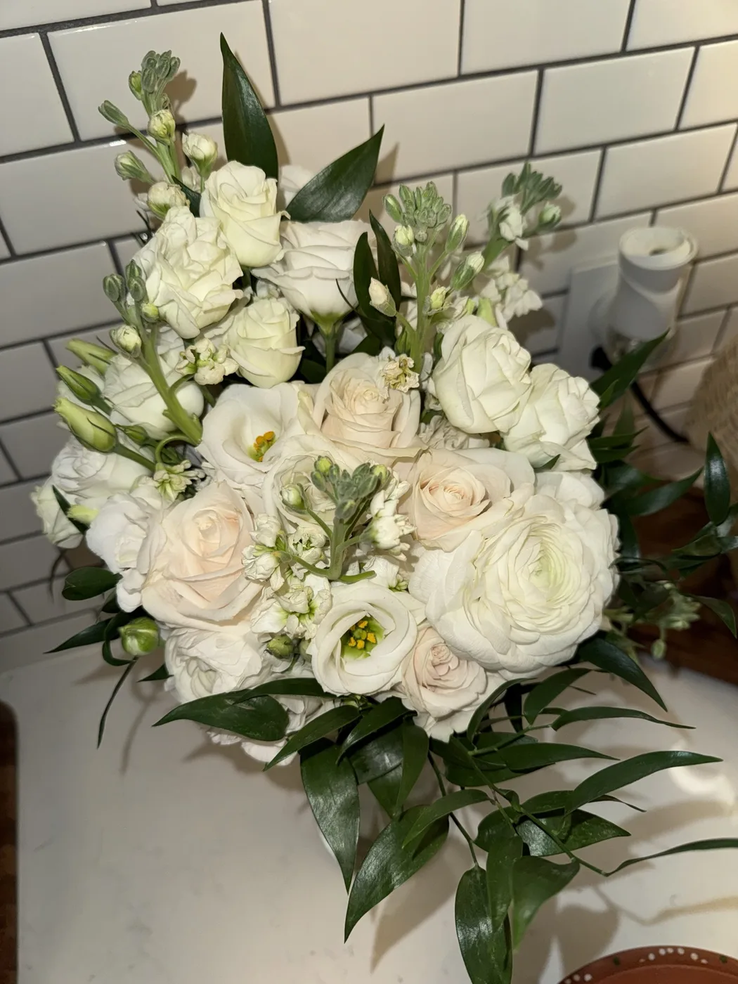 A fresh white rose and greenery bridal bouquet